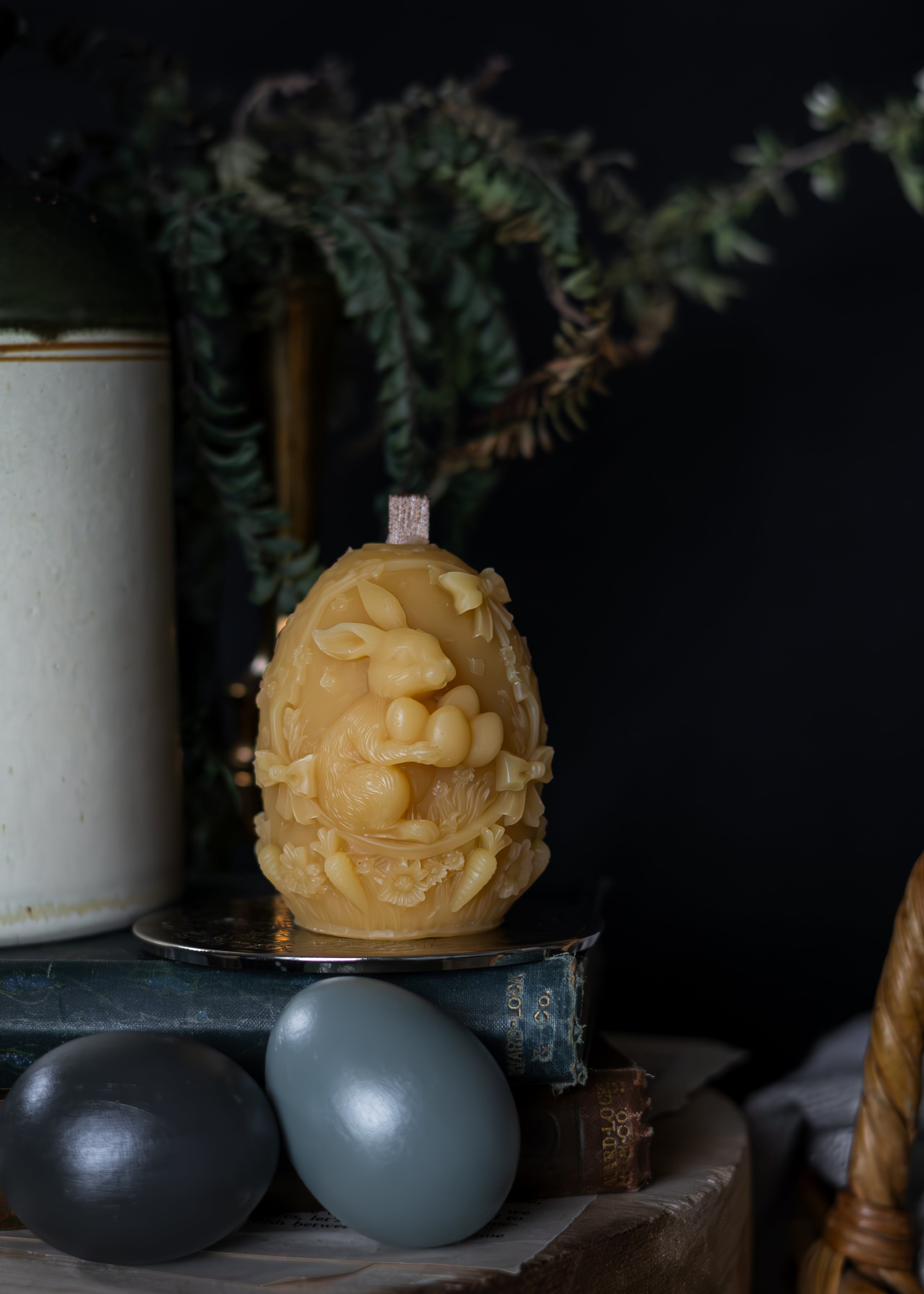 Decorative egg with intricate design on a dark background, tasmanian beeswax candle