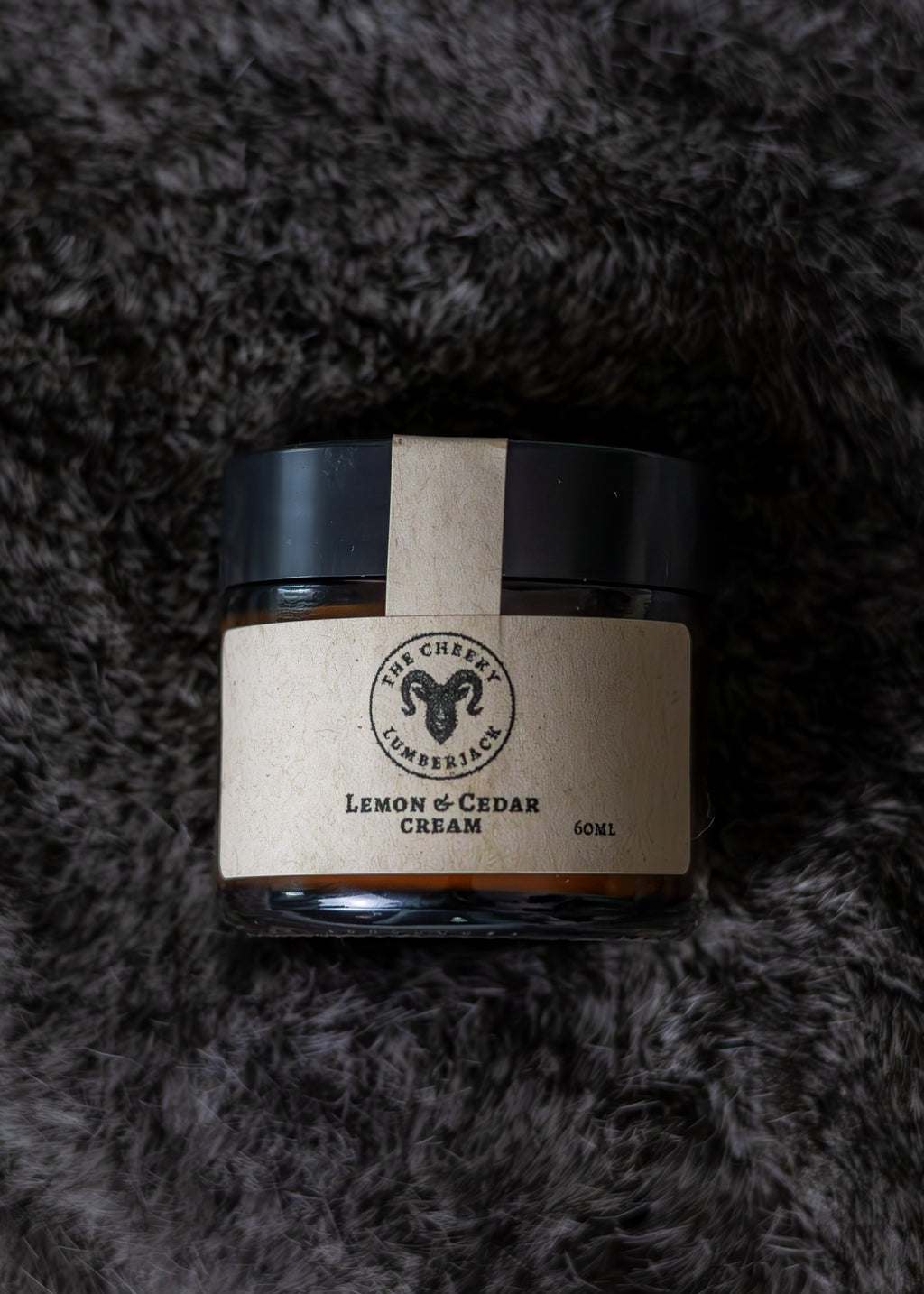 Jar of cream with a label on a textured gray background