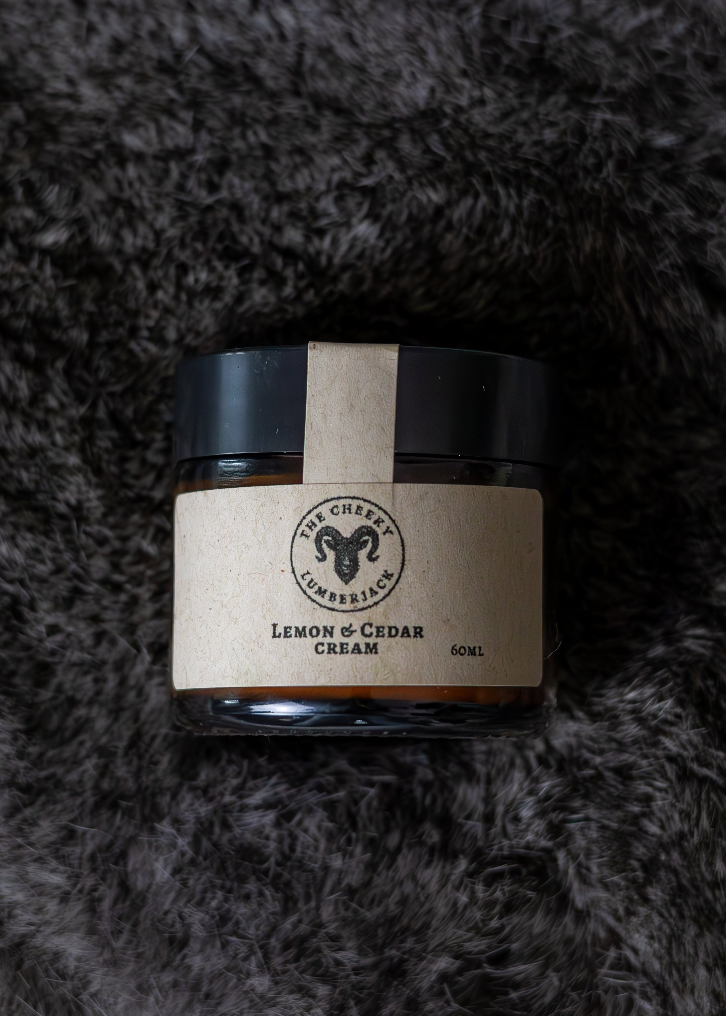 Jar of cream with a label on a textured gray background