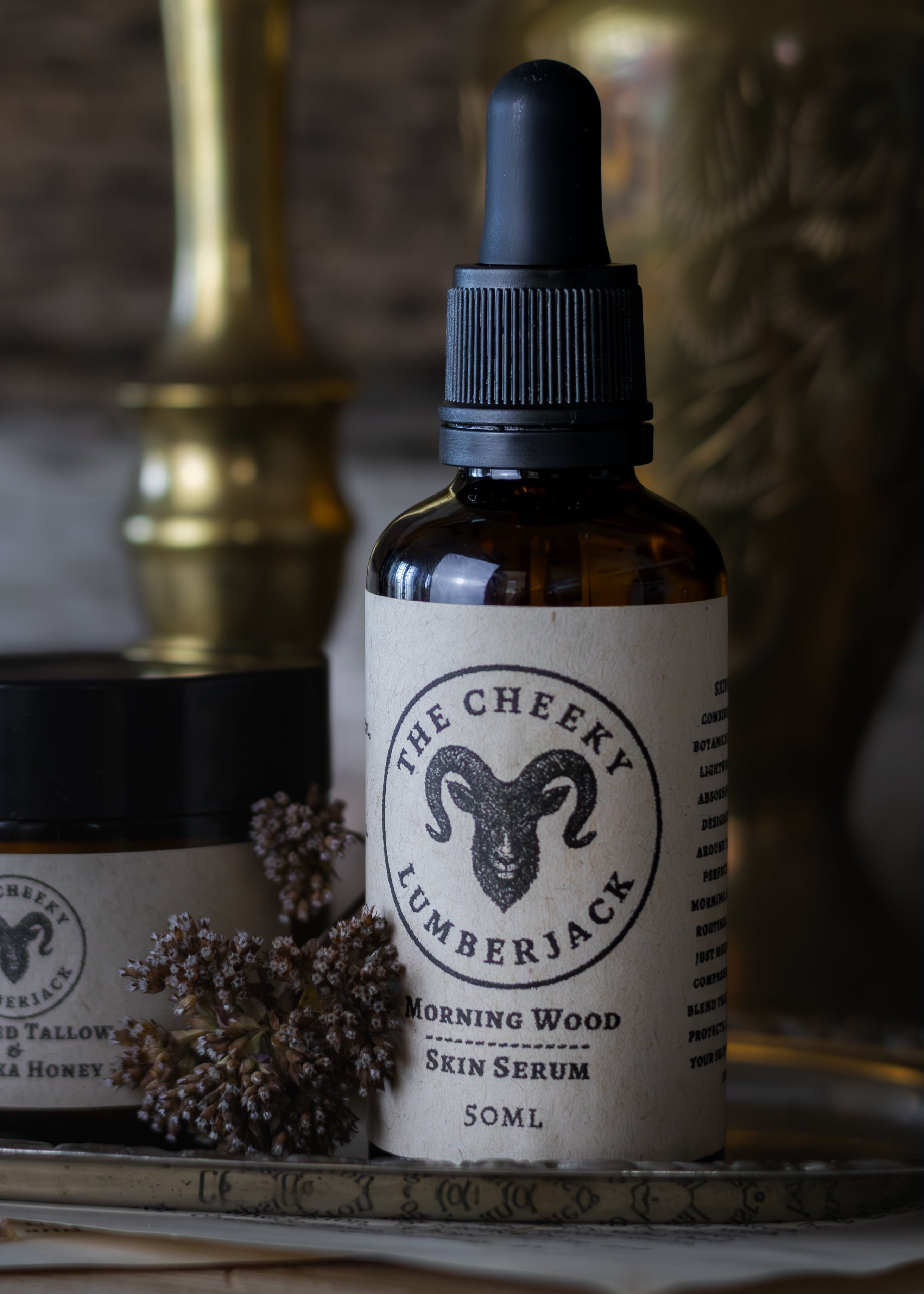 Bottle of 'The Cheeky Lumberjack' skin serum and a jar on a rustic surface with a blurred background.