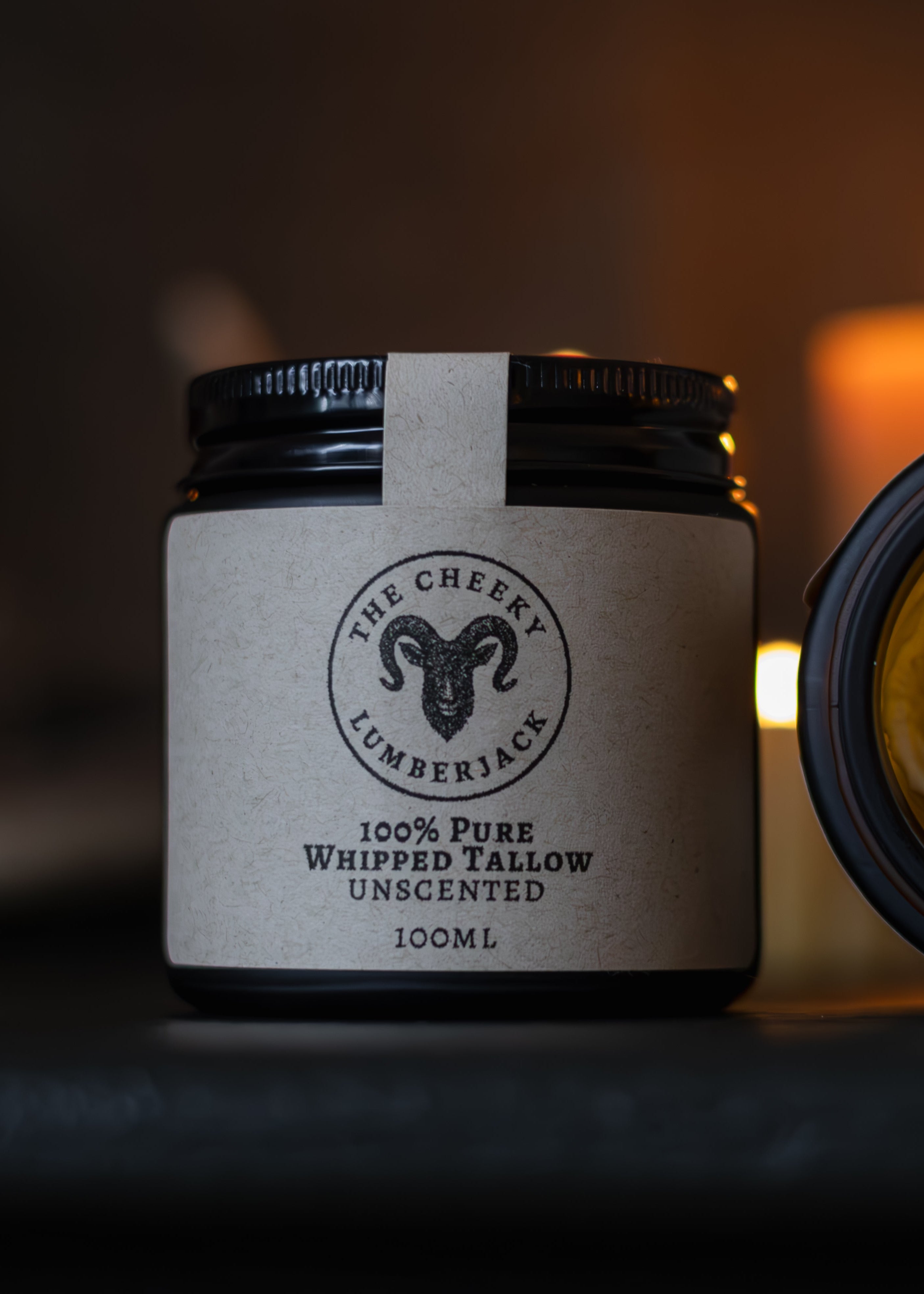 Jar of whipped tallow cream with a visible brand label on a dark background