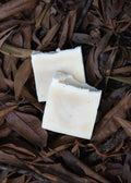 Morning Wood Tallow & Beeswax Soap bars resting on dried brown leaves.
