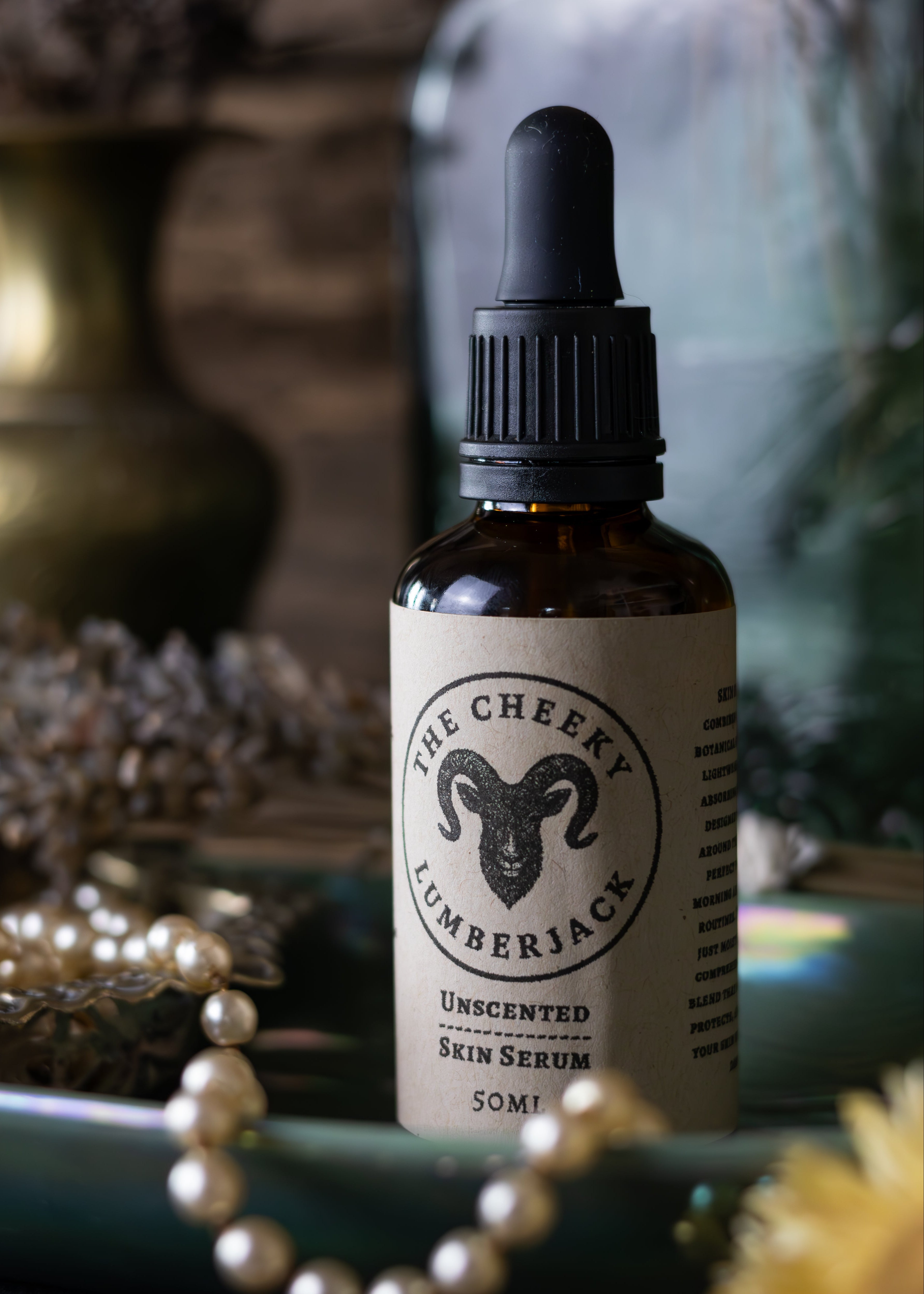 Bottle of 'The Cheeky Lumberjack' unscented skin serum on a decorative surface with blurred background